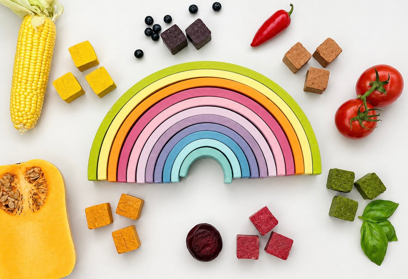 A wooden rainbow with rainbow coloured fruits and vegetables surrounding