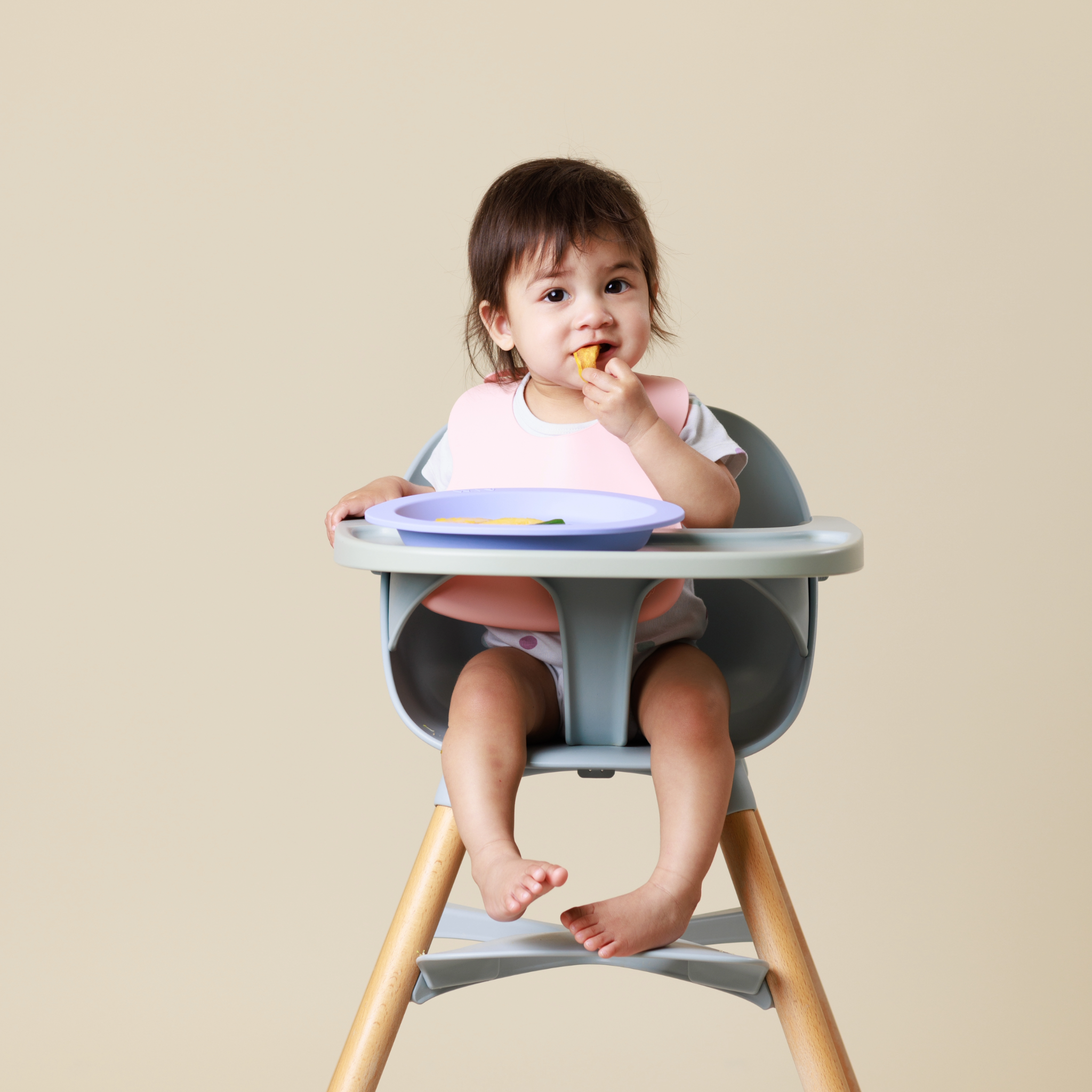 Baby in highchair eating finger food from Audrey and Alfie, as part of baby-led weaning