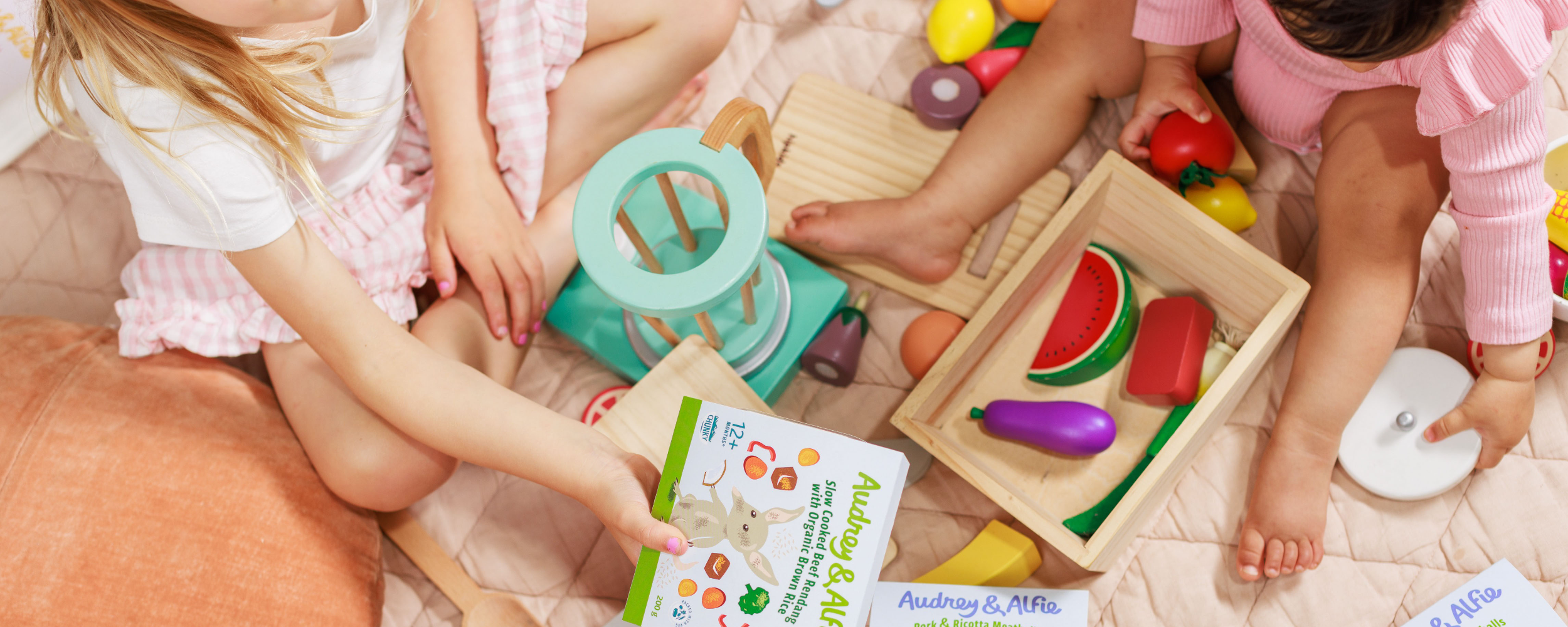 Children playing with wooden fruits and veggies and Audrey & Alfie Packets