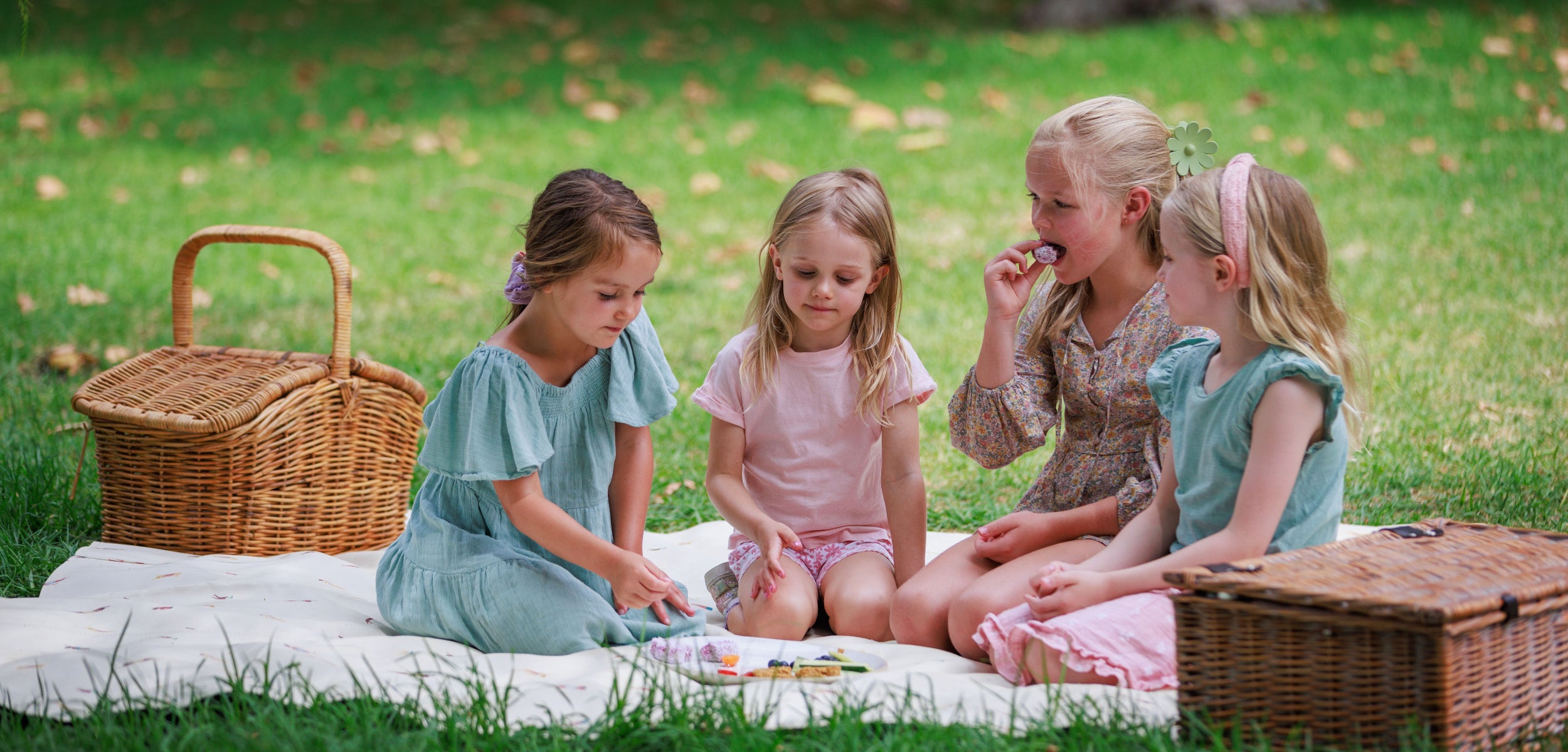 Four girls enjoying a picnic and eating Audrey & Alfie's Finger Food