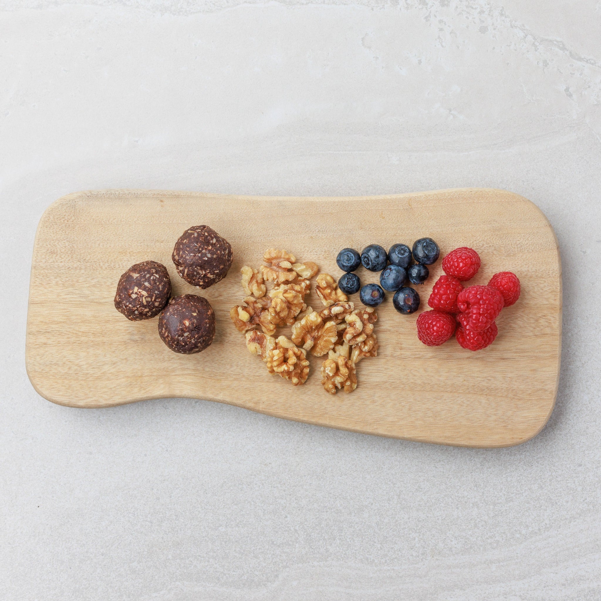A plate of Raw Peppermint Chocolate Date Balls with fruit and nuts from Audrey and Alfie's Finger Food Range