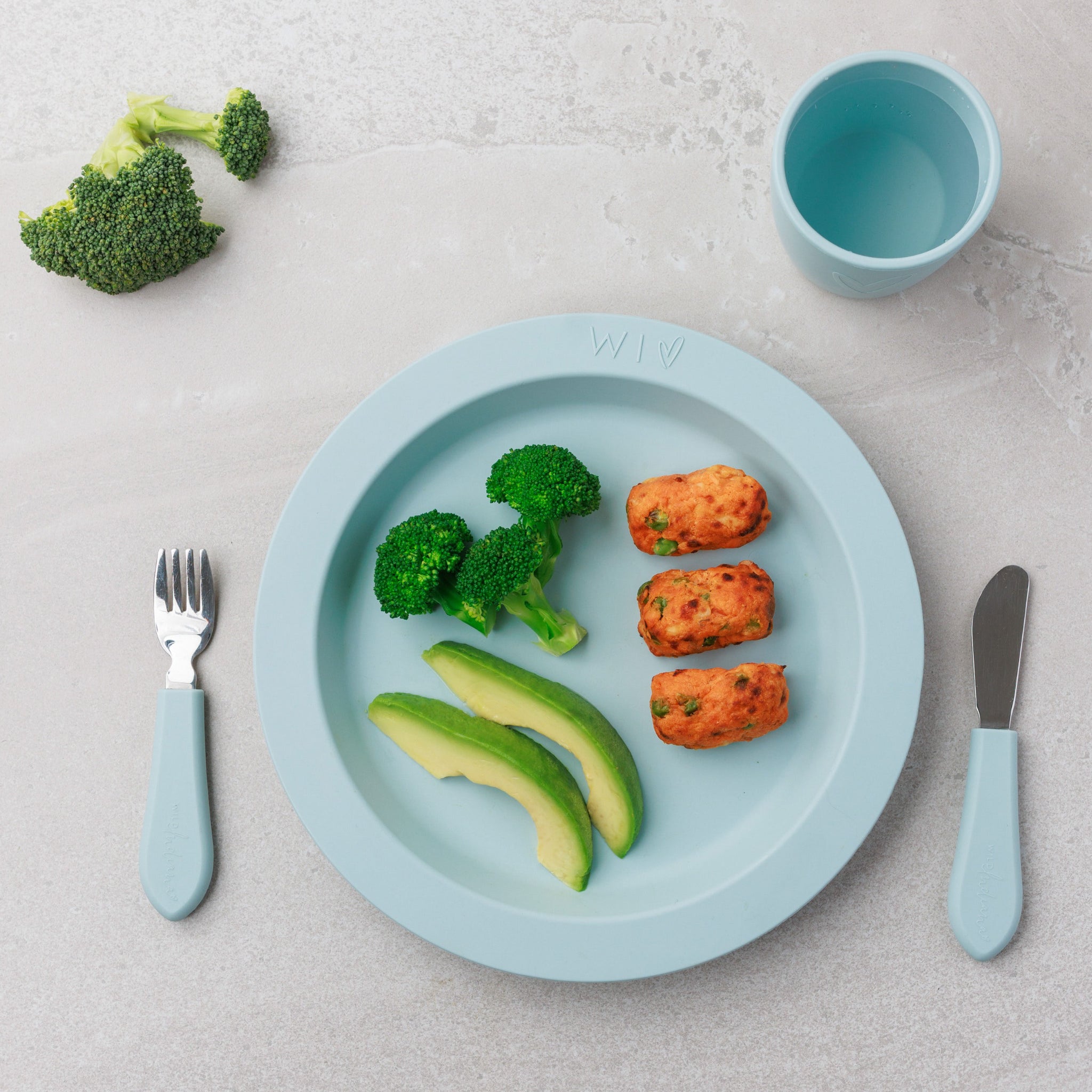 A plate of Sweet Potato Salmon Bites paired with sides of green veggies from Audrey and Alfie's Finger Food Range