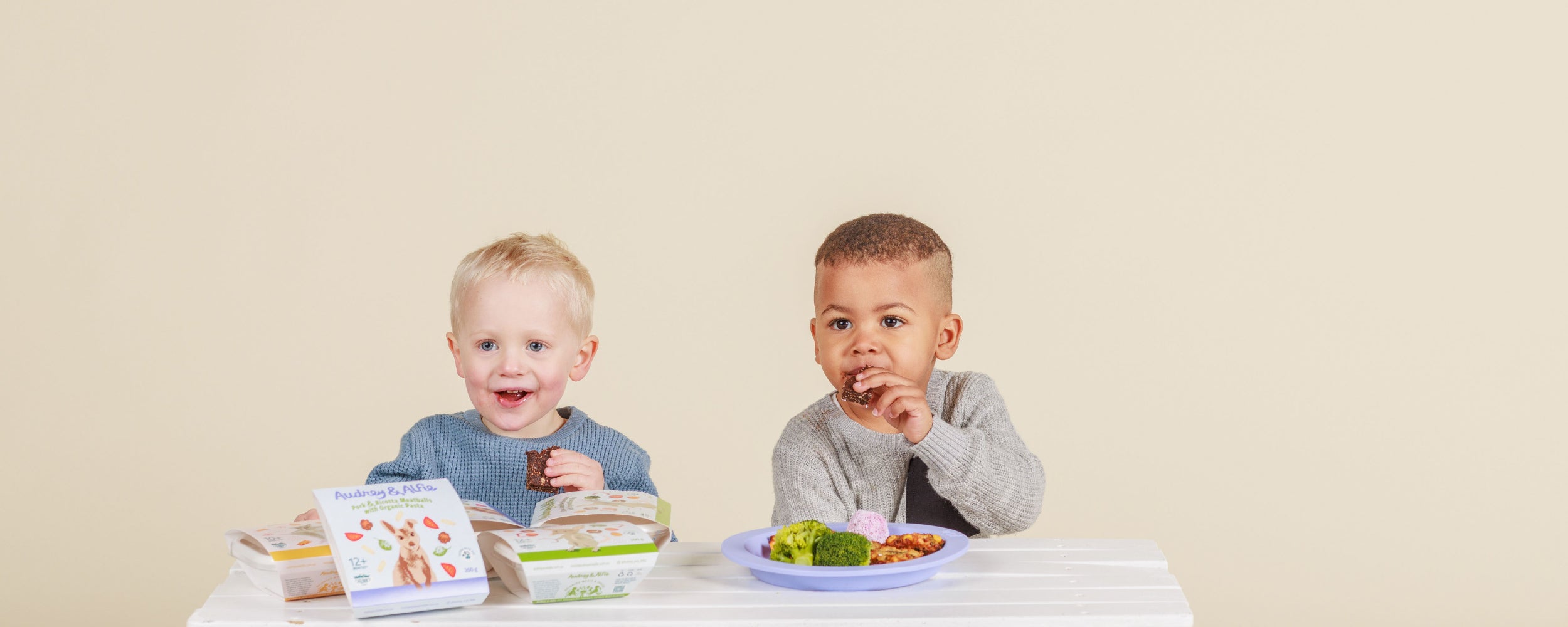 Two Toddlers smiling and eating Audrey and Alfie Finger Food